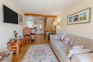ein Wohnzimmer mit Couch und Flachbildfernseher in der Unterkunft Archway Cottage - Caldbeck in Caldbeck