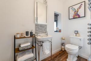 a bathroom with a white toilet and a sink at Westfield Retreat in Hunmanby