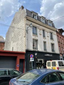 a tall white building with a pyramid top on a street at Appartement 80m2 à deux pas du beffroi in Arras