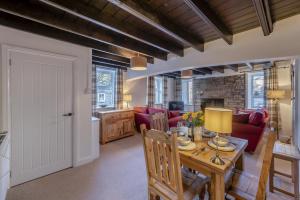 Una cocina y una sala de estar con mesa y sillas. en Cherry Tree Cottage - Langthwaite, en Low Eskcleth