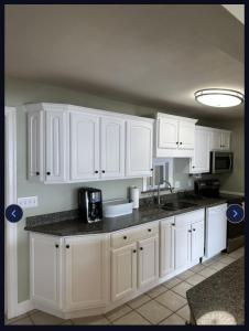 a kitchen with white cabinets and a black counter top at Marr Castle in Onsted +11 photos