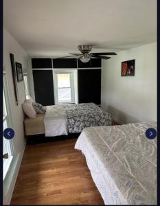 a bedroom with two beds and a ceiling fan at Marr Castle in Onsted +9 photos
