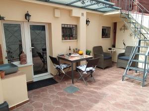 a patio with a table and chairs and a staircase at Orfeas Home/Detached House 74m2,parking&yard in Volos