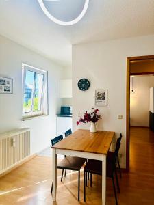 a dining room table with chairs and a vase with flowers at Appartment am Bahnhof Mitte in Dresden