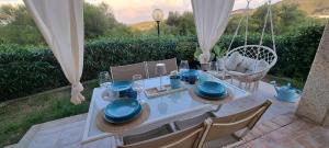 a white table with blue dishes on top of it at Casa Cala Sardegna Budoni Residence con Piscina in Budoni