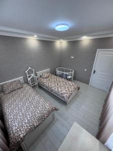 a bedroom with two beds and a crib at Apple Garden Guba in Quba +13 photos