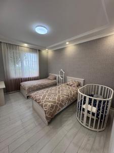 a bedroom with two beds and a crib in it at Apple Garden Guba in Quba