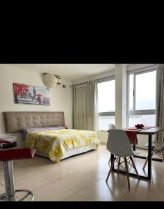a bedroom with a bed and a desk and a table with a chair at Departamento terrazas II in La Plata