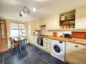 a kitchen with a washing machine and a table at Low Moor Farm in Cotterdale