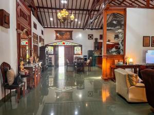 a lobby with chairs and tables in a building at Ndalem Srigading Villa Solo in Bonorejo