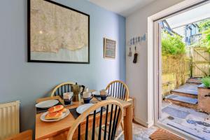 een eetkamer met een tafel en stoelen en een deur bij Pink Cottage in Beer +14 foto's
