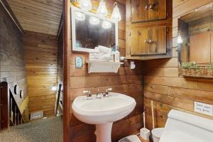 a bathroom with a white sink and wooden walls at Stone's Throw in Welches +34 photos