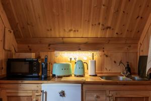 a kitchen counter with a sink and a microwave at The Sigló House in Siglufjörður