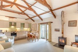 cocina y sala de estar con mesa y chimenea en The Granary, en Lewannick