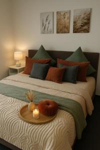 a bed with a tray with a candle on it at Ferienwohnung Elya, Ihre Auszeit zwischen Therme, Outlet, Natur in Bad Münstereifel