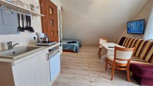 a kitchen with a sink and a table and a couch at Harpun in Władysławowo