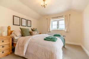 une chambre avec un grand lit et une fenêtre dans l'établissement No Road - The Cottage, à Bewdley