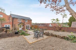 d'une terrasse avec une table et des chaises dans le jardin. dans l'établissement No Road - The Cottage, à Bewdley