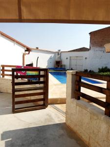 una recinzione di legno di fronte a una casa con piscina di Hoya del Agua Casa Rural a Casas de Haro