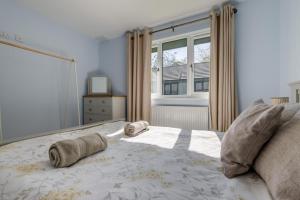 Un dormitorio con una cama con dos almohadas y una ventana. en Heather - Bude, en Bude