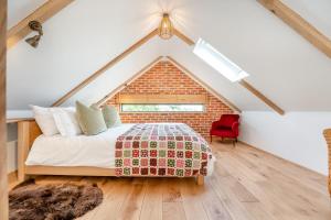 een slaapkamer met een bed en een bakstenen muur bij Great Knights Cottage in Westfield