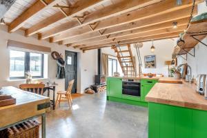 een keuken met groene kasten en een eetkamer bij Great Knights Cottage in Westfield