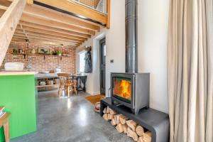 een open haard in de woonkamer met een fornuis bij Great Knights Cottage in Westfield