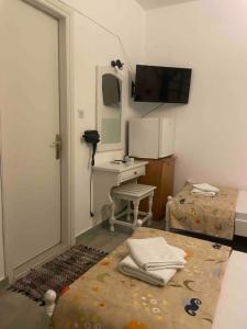 a room with a bed with a desk and a mirror at rigas-zoi 5 in Skiathos
