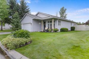 a white house with a green yard at Blue Grass Bungalow in Coeur d'Alene