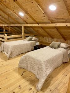 two beds in a room with a wooden ceiling at Rancho Áustria - Hospedagem Exclusiva in Treze Tílias