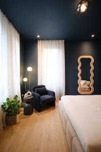 a bedroom with a large bed and a chair at Premier Stay The Balcony - Bernina Experience in Tirano +8 photos