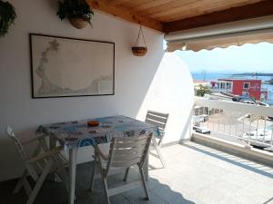 a table and chairs on a balcony with a view of the ocean at "Casa Lungomare" Stintino paese in Stintino