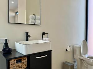 a bathroom with a white sink and a toilet at Ariché en Valle de Guadalupe in Valle de Guadalupe +41 photos