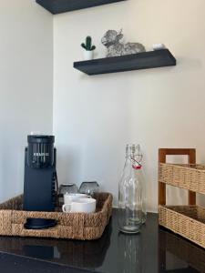 a table with a coffee maker and a bottle on it at Ariché en Valle de Guadalupe in Valle de Guadalupe
