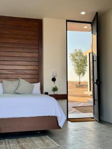 a bedroom with a bed and a sliding glass door at Ariché en Valle de Guadalupe in Valle de Guadalupe