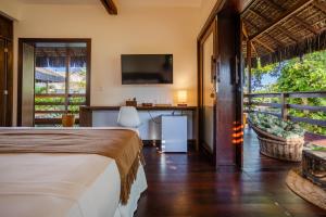a bedroom with a bed and a desk and a television at Villa Ventana - Aldeia Jericoacoara Group in Jericoacoara