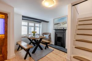 ein Esszimmer mit Tisch und Kamin in der Unterkunft Shipwrights Cottage - Appledore in Appledore