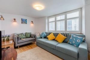 ein Wohnzimmer mit einem blauen Sofa und einem Sessel in der Unterkunft Shipwrights Cottage - Appledore in Appledore