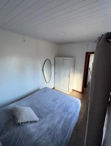 ein Schlafzimmer mit einem blauen Bett und einem Spiegel in der Unterkunft Casa contenedor VoVo in Barra de Portezuelo
