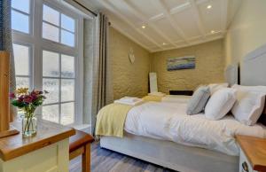 a bedroom with a large bed and a large window at Hideaway in Appledore