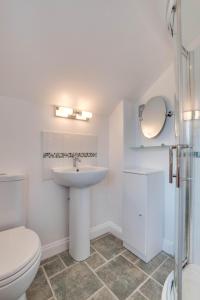 a white bathroom with a toilet and a sink at The Hop House in Welcombe