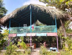a house with a thatched roof with a deck at daTerra Vilaverde in Dili