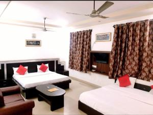 a hotel room with two beds and a couch at Hotel Prashant Palace in Agra +9 photos