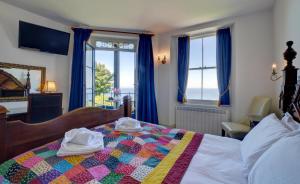 ein Schlafzimmer mit einem Bett mit einer Steppdecke darauf in der Unterkunft The Orangery Lynton Cottage in Lynmouth