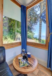 ein Wohnzimmer mit einem Tisch und einem Fenster in der Unterkunft The Orangery Lynton Cottage in Lynmouth