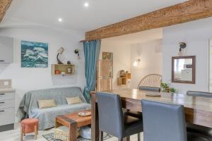 a kitchen and living room with a table and chairs at Maisonnette d'Artiste au cœur des ruelles médiévales in Trévoux