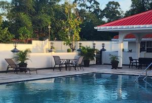 a patio with a table and chairs next to a swimming pool at Ideal Executive Suites in Georgetown