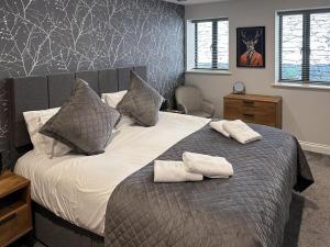 ウィンダミアにあるBam Lodge @ Applethwaite Hallのベッドとタオル2枚のある寝室