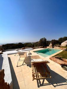 a patio with chairs and a swimming pool at DomoMea Porto Cervo in Abbiadori +21 photos