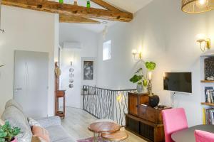 a living room with a couch and a tv at Maisonnette d'Artiste au cœur des ruelles médiévales in Trévoux